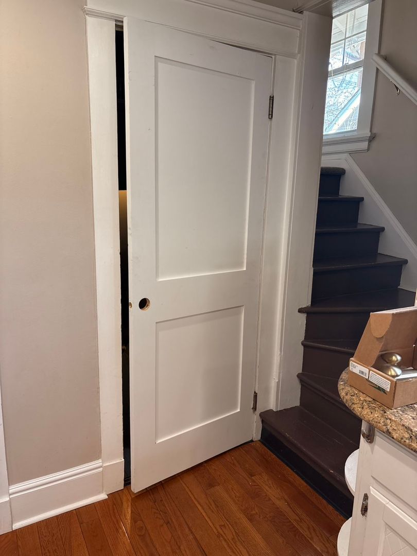 White pocket door installed in a hallway beside a staircase