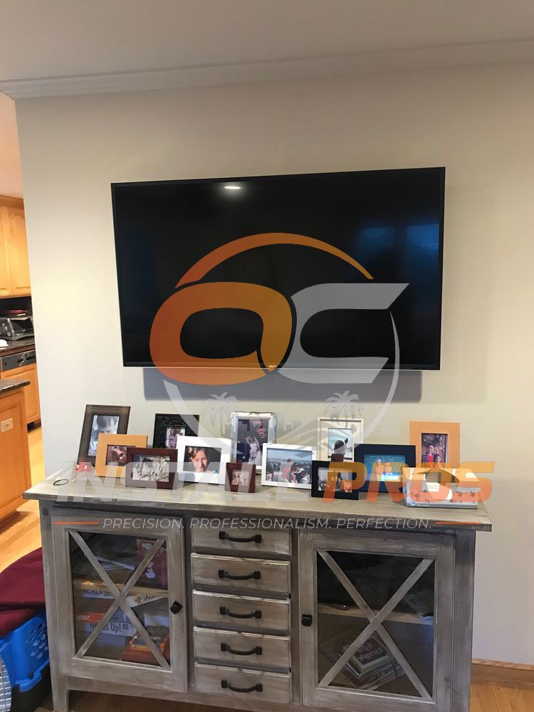 Flat-screen TV mounted on a living room wall above a wood console table